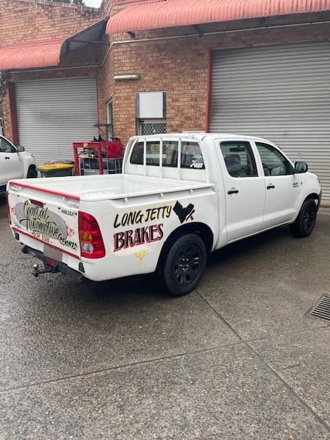 A White Truck in Front of a Building — Coastal Automotive Services Long Jetty in Long Jetty, NSW