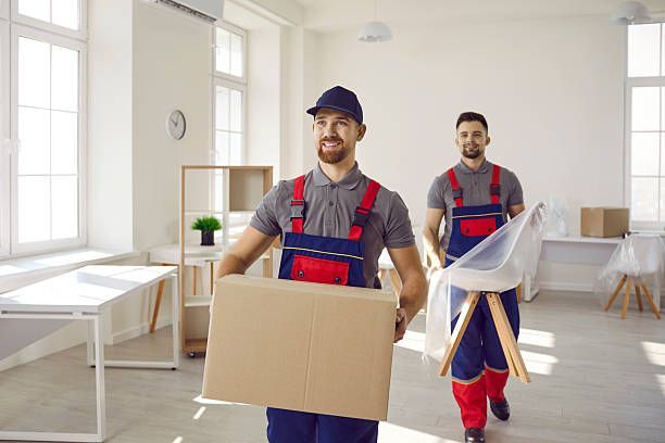 Professional movers carrying boxes inside a home.