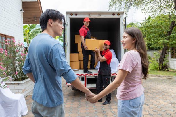 Couple holding hands next to a moving truck