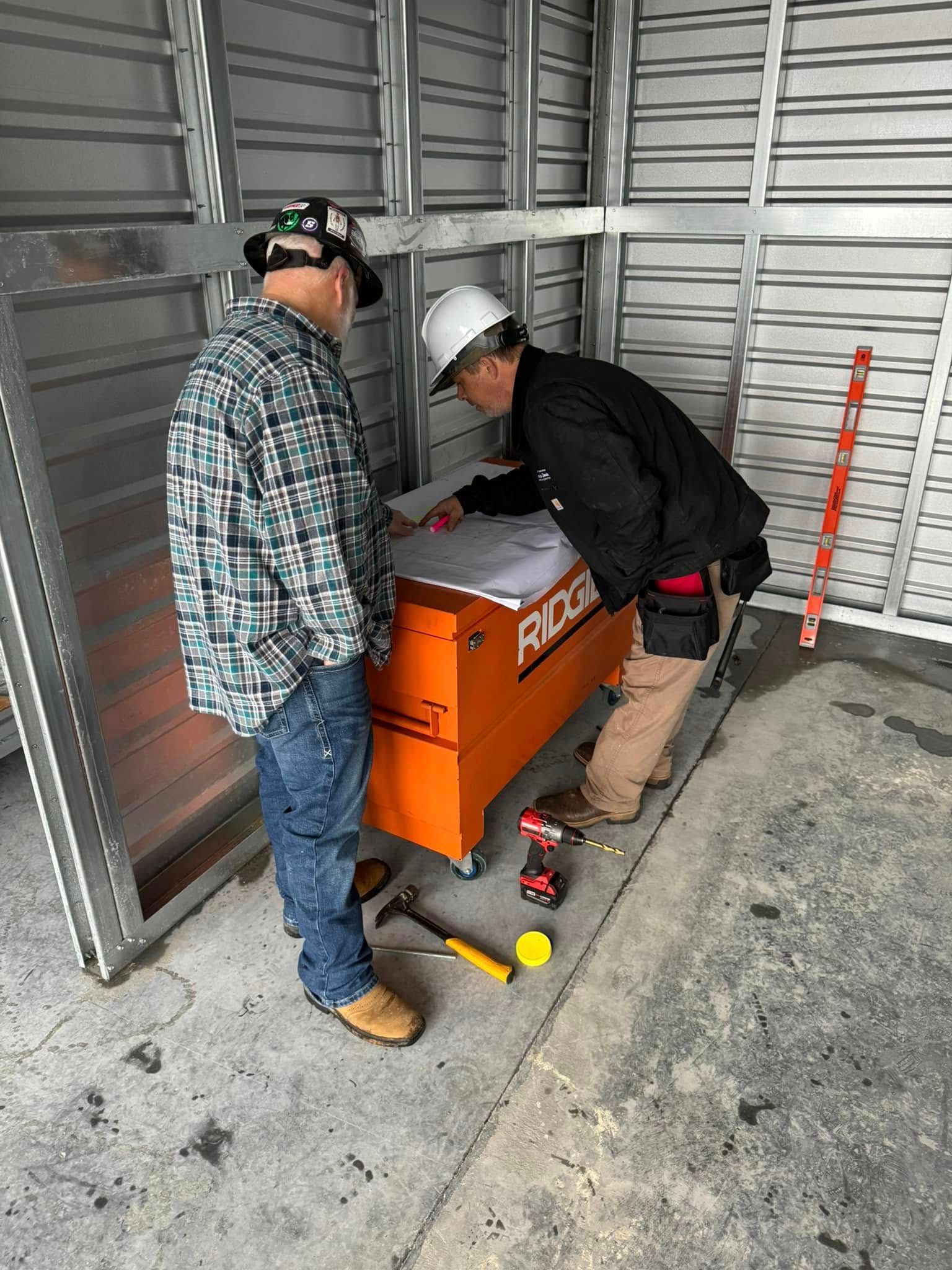 Two men are working on a toolbox in a garage.