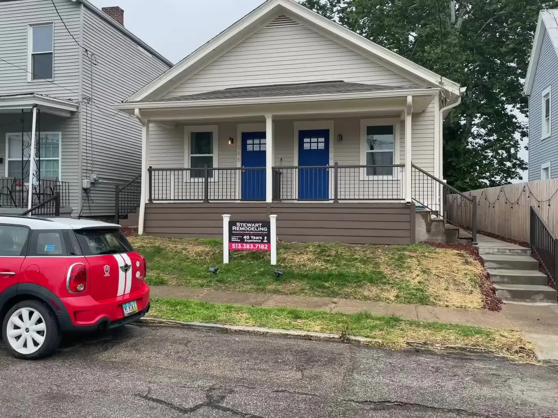 A red mini cooper is parked in front of a house.
