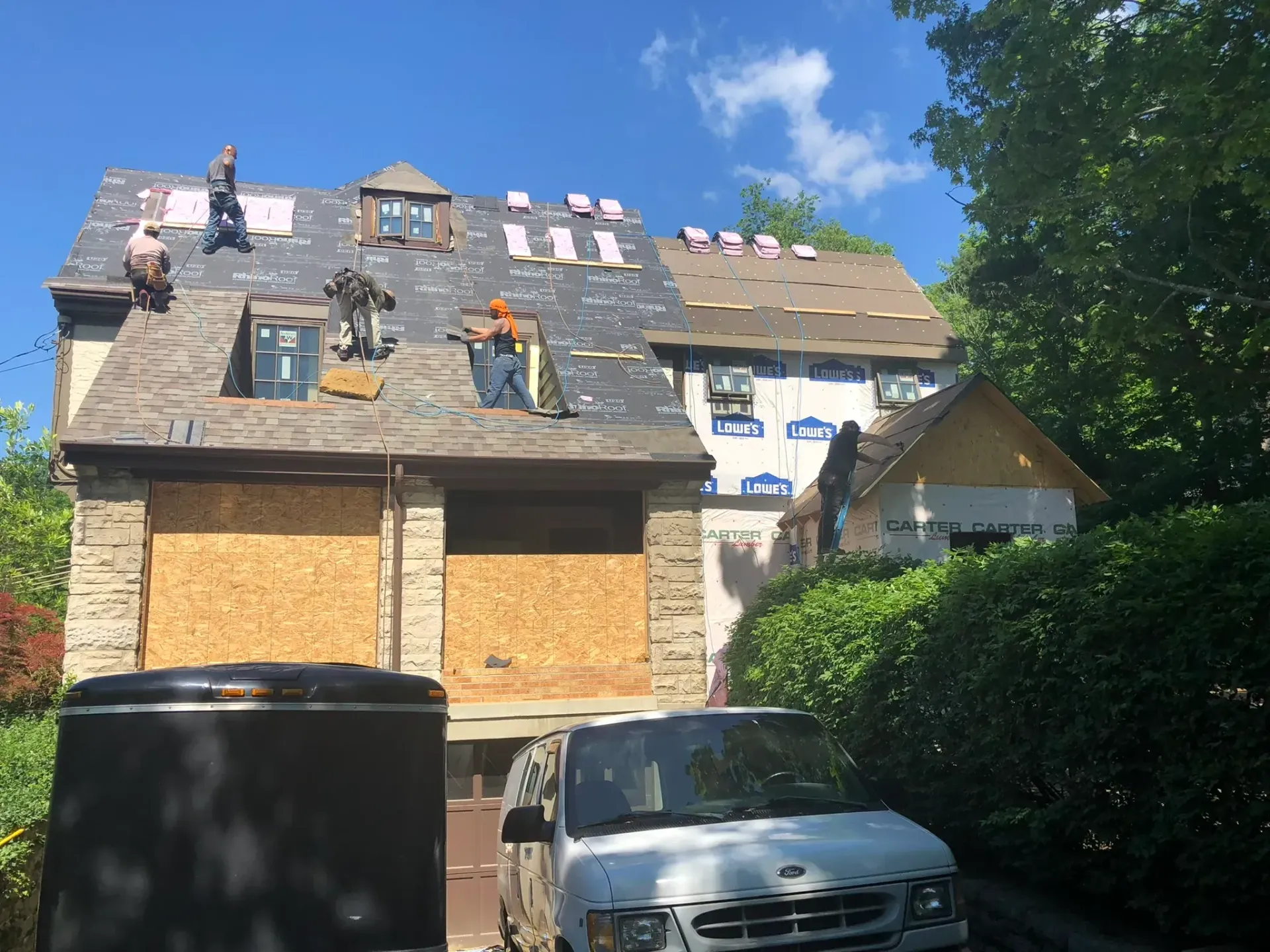 A white van is parked in front of a house that is being remodeled.