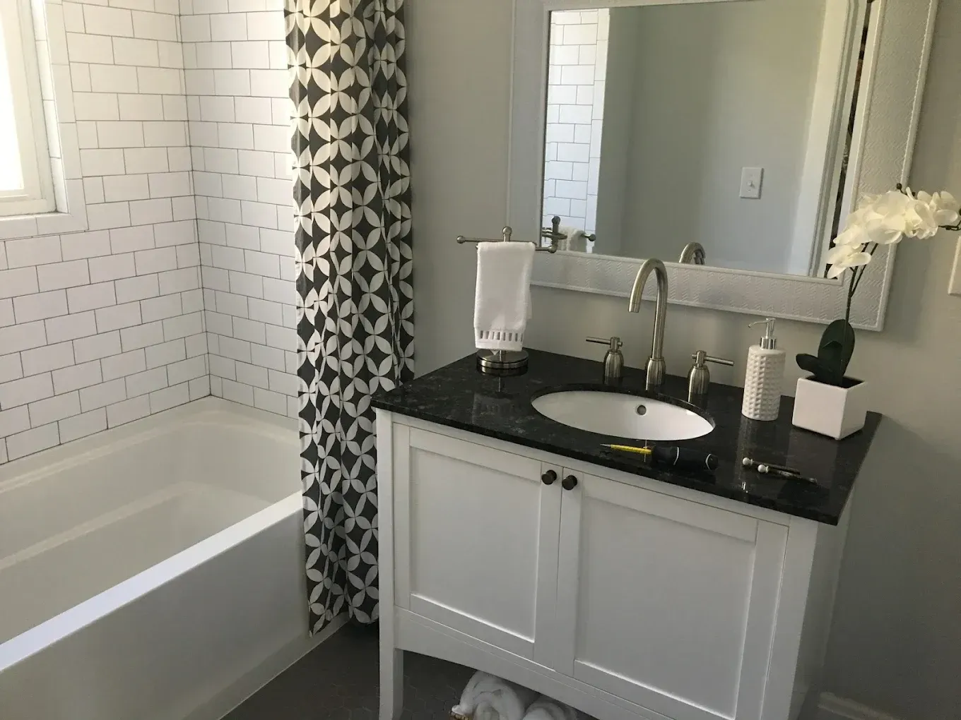 A bathroom with a sink , mirror and bathtub.
