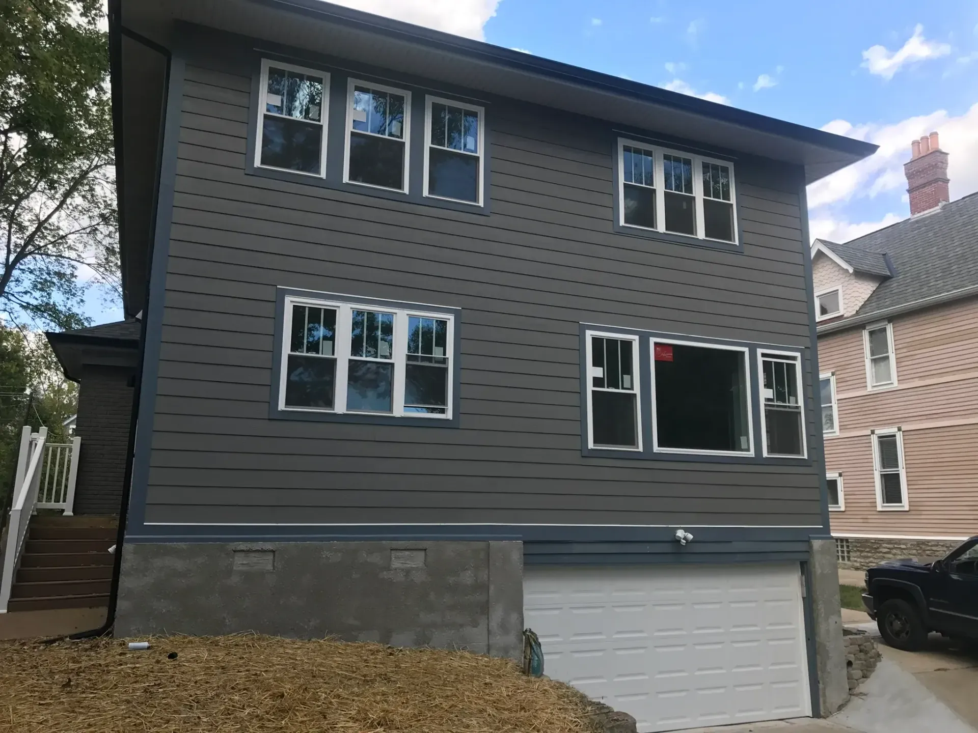 A large house with a lot of windows and a car parked in front of it.
