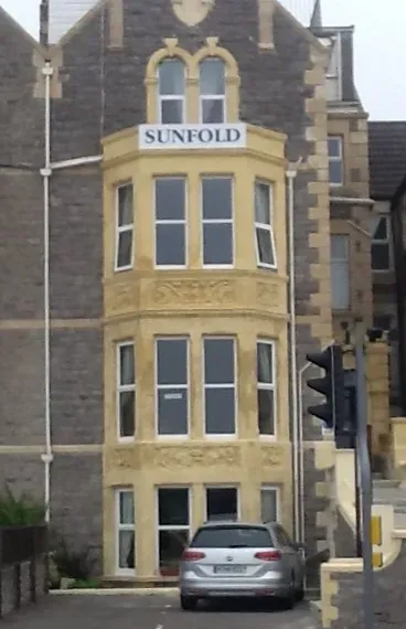 A car is parked in front of a building that says sunfold