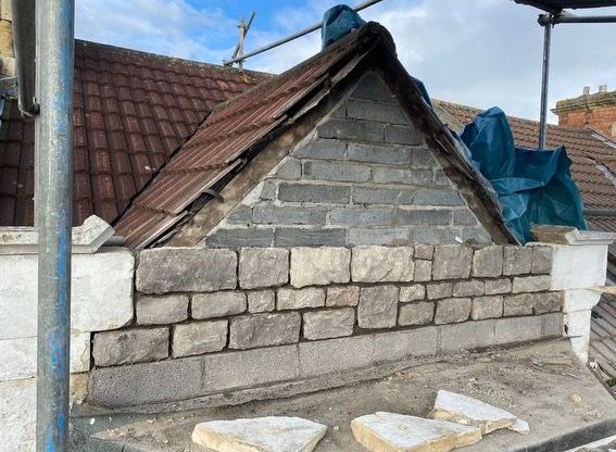 A brick wall is being built on the side of a building.