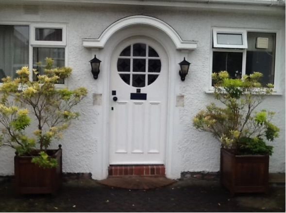 A white house with a white door with a round window