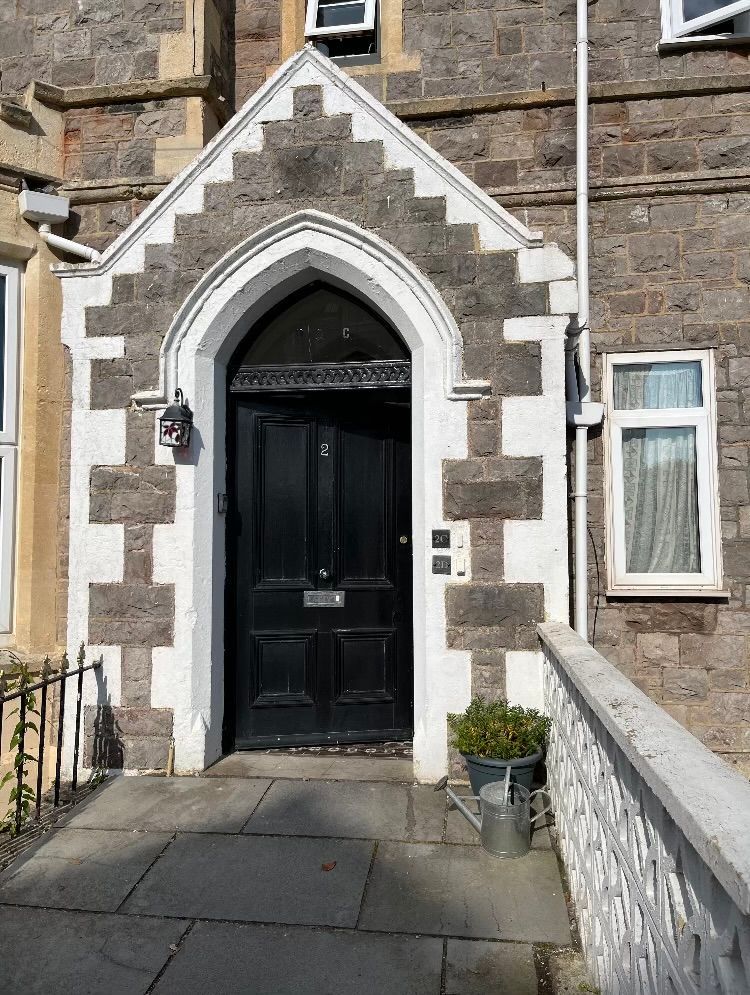 The front door of a brick building with a black door