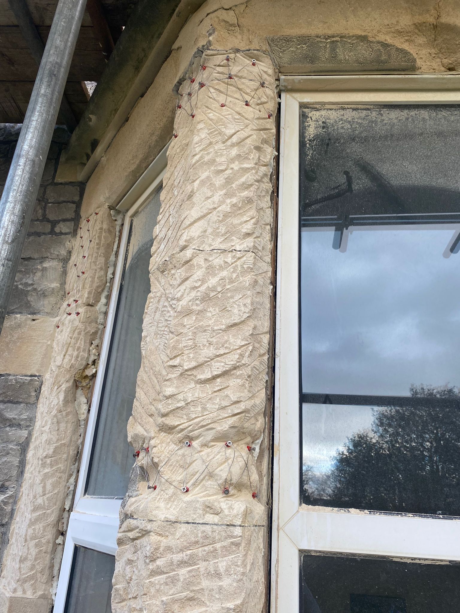 A close up of a window on a building with a pillar in the background.