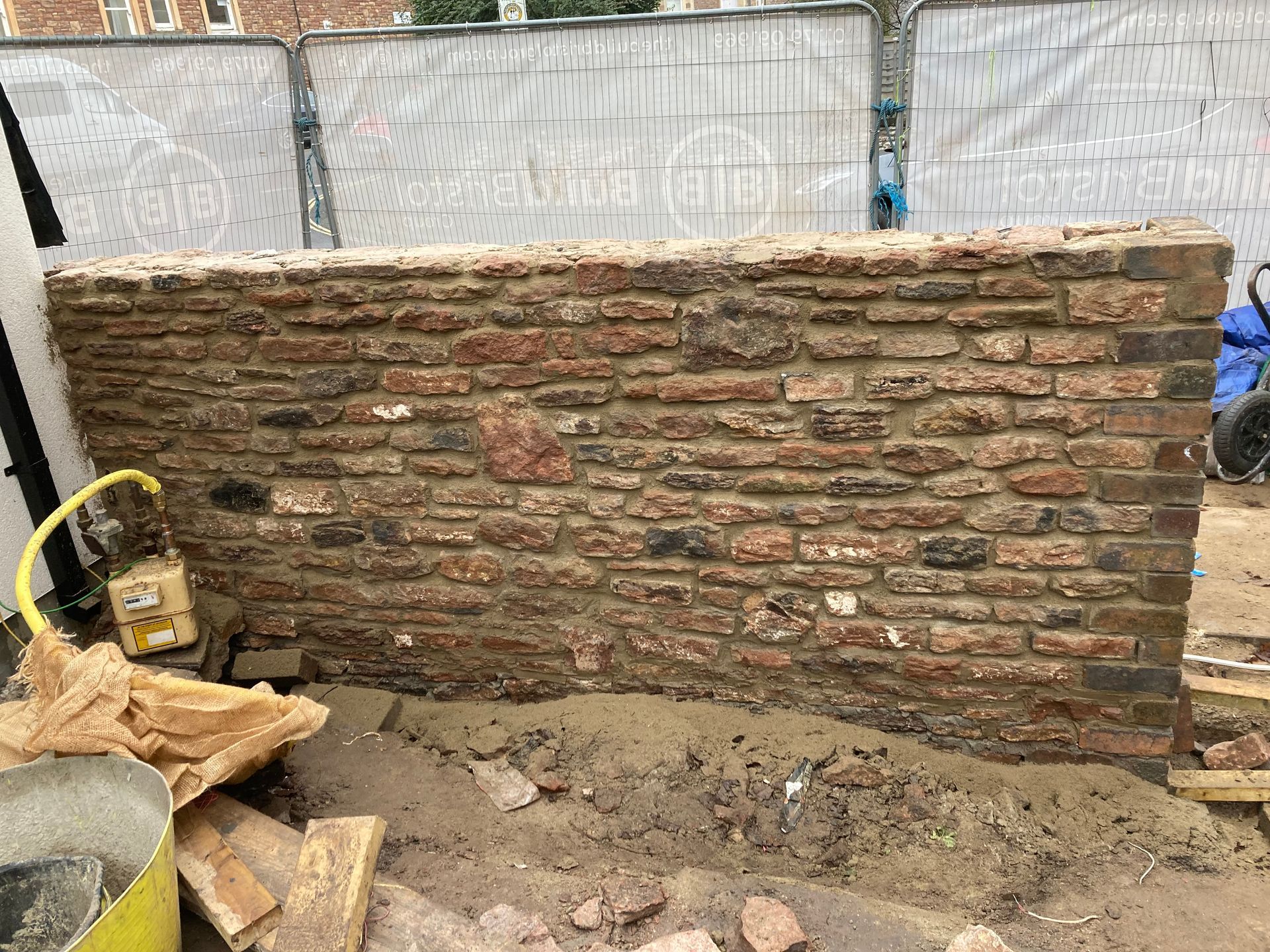 A brick wall is being built on a construction site.