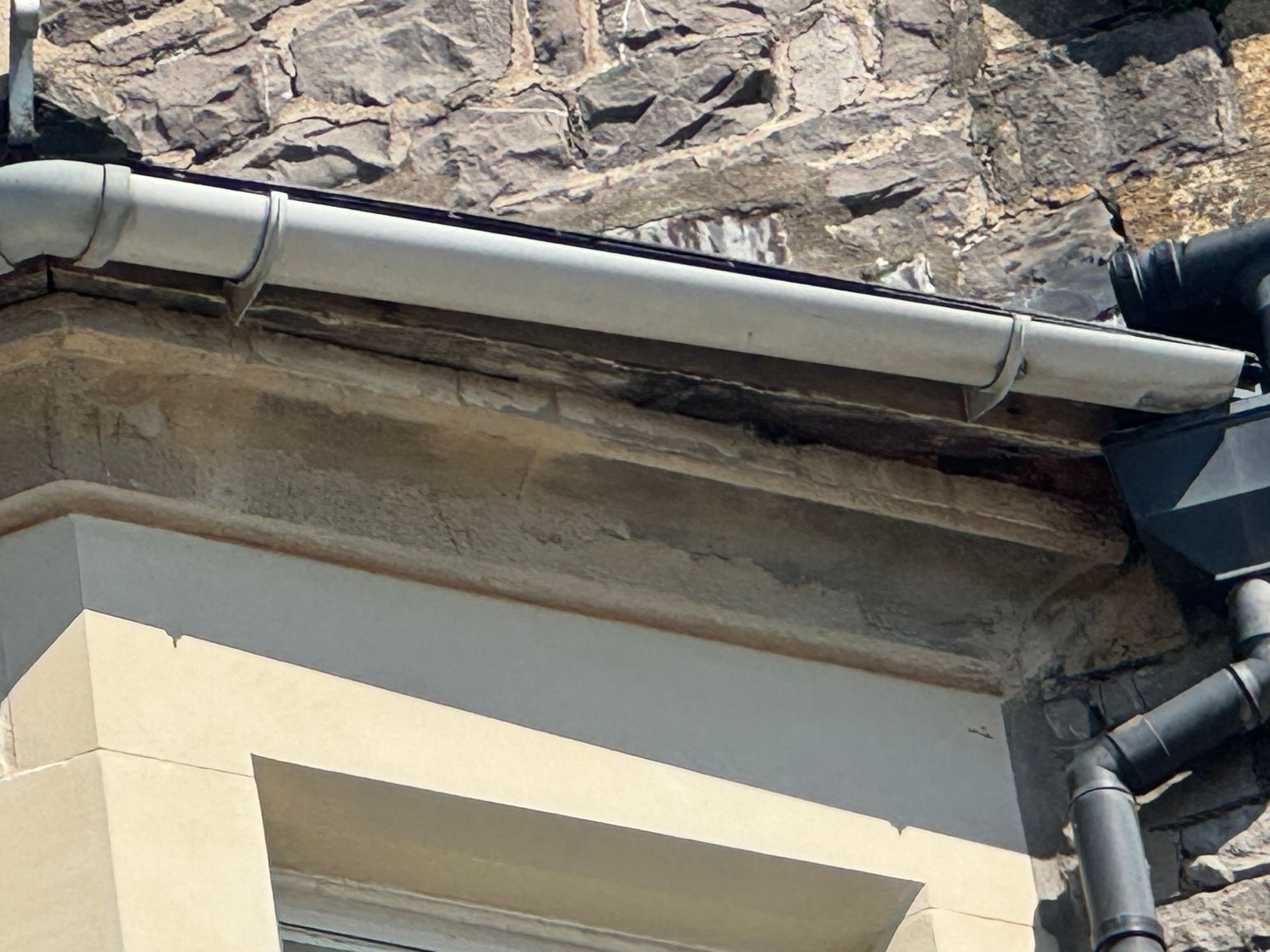 A close up of a gutter on the side of a building.