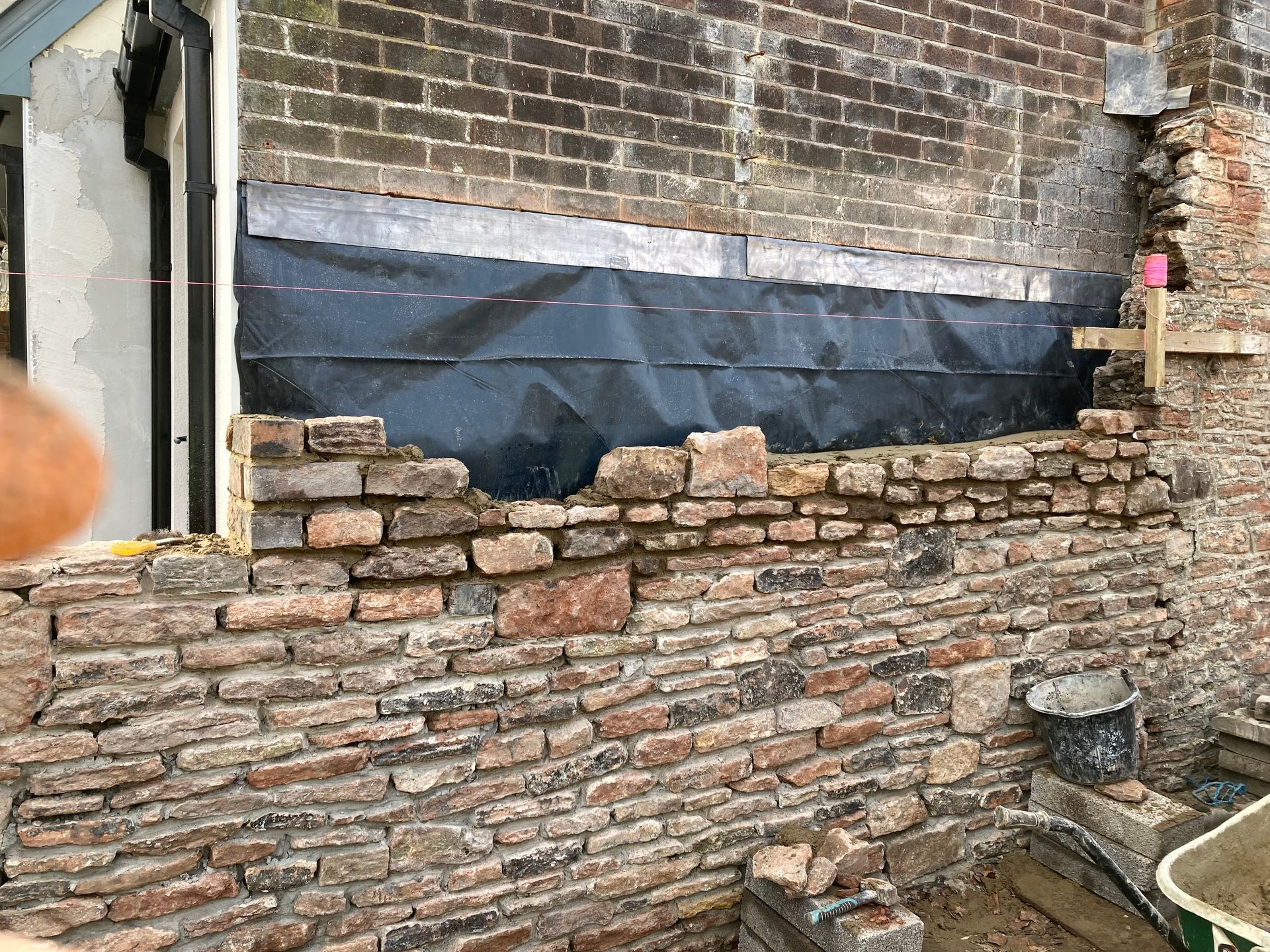 A brick wall is being built on the side of a building.