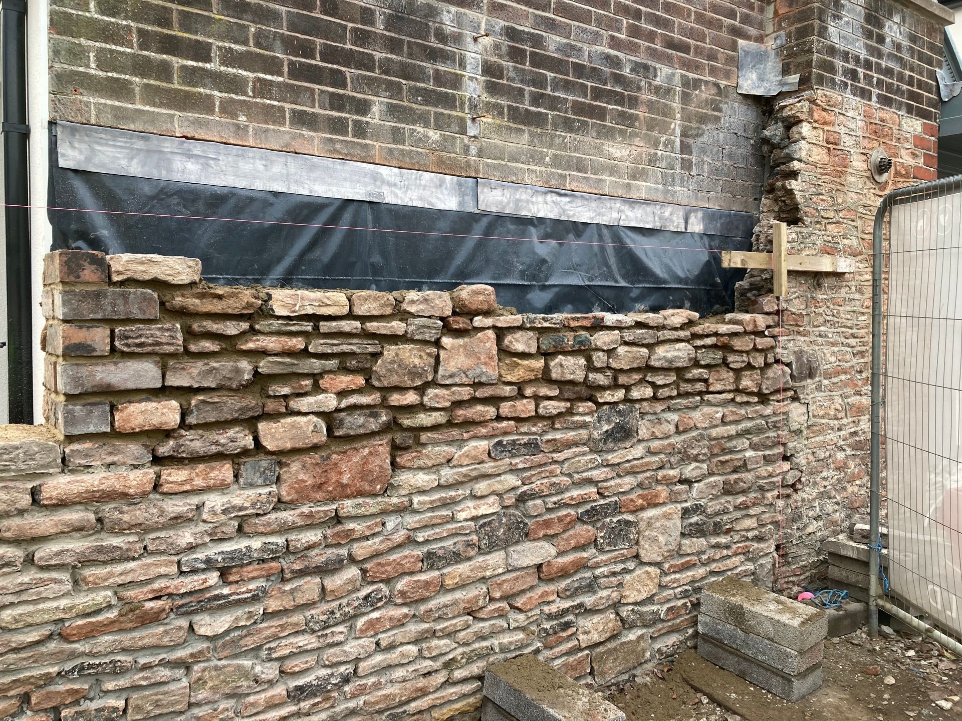A brick wall is being built on the side of a building.