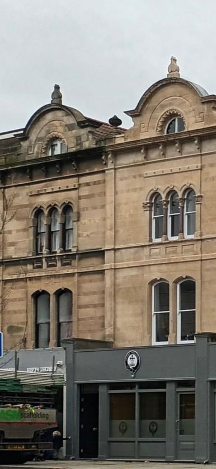 A large brick building with a gray building in front of it.