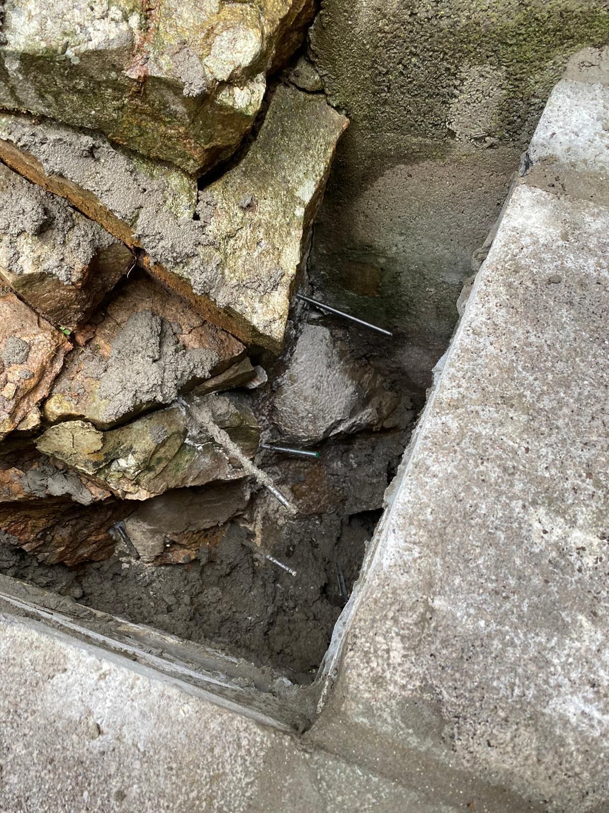 A frog is sitting on top of a pile of rocks.