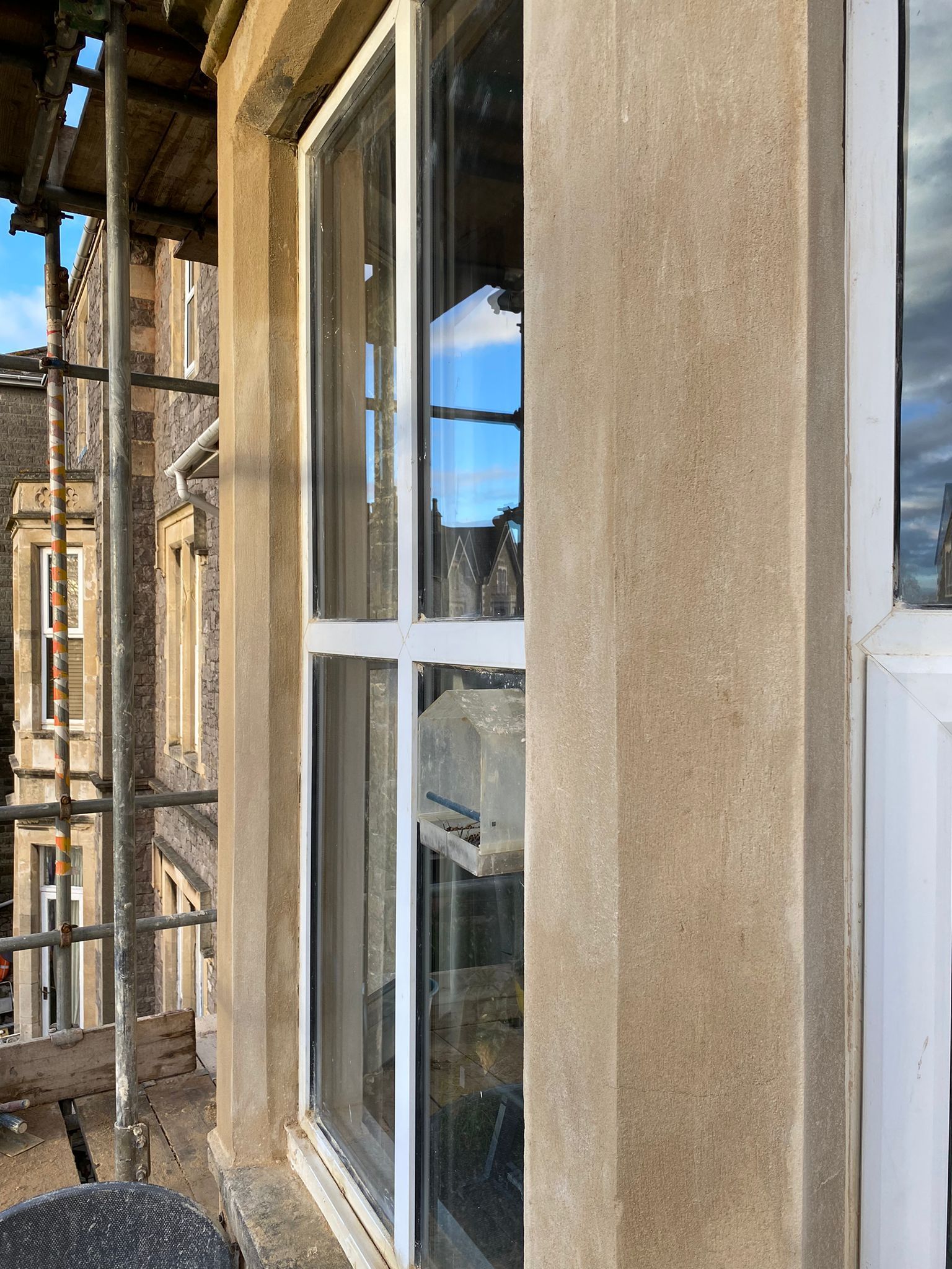 A window on the side of a building with scaffolding around it.