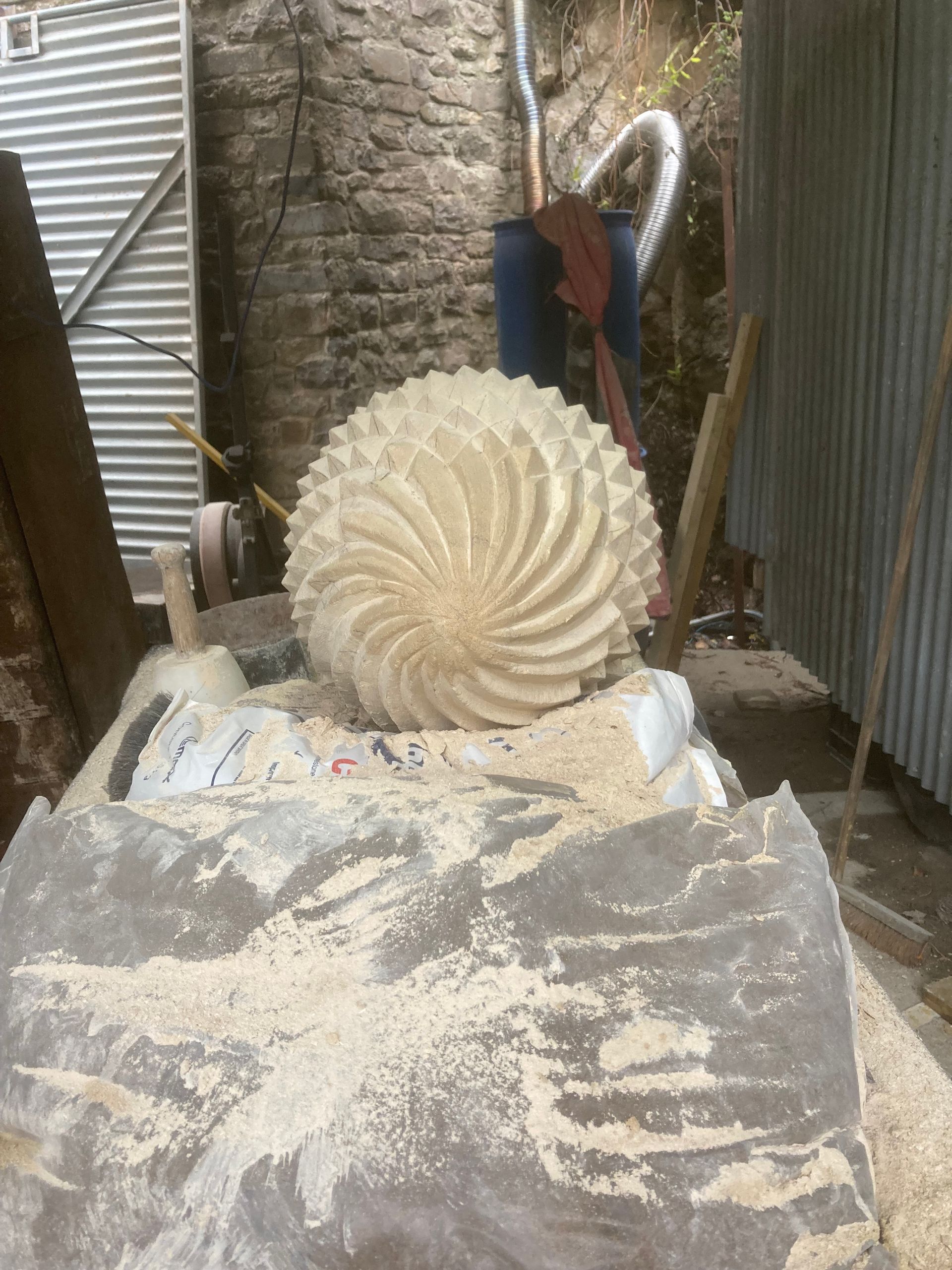 A large circular object is sitting on top of a pile of wood chips.