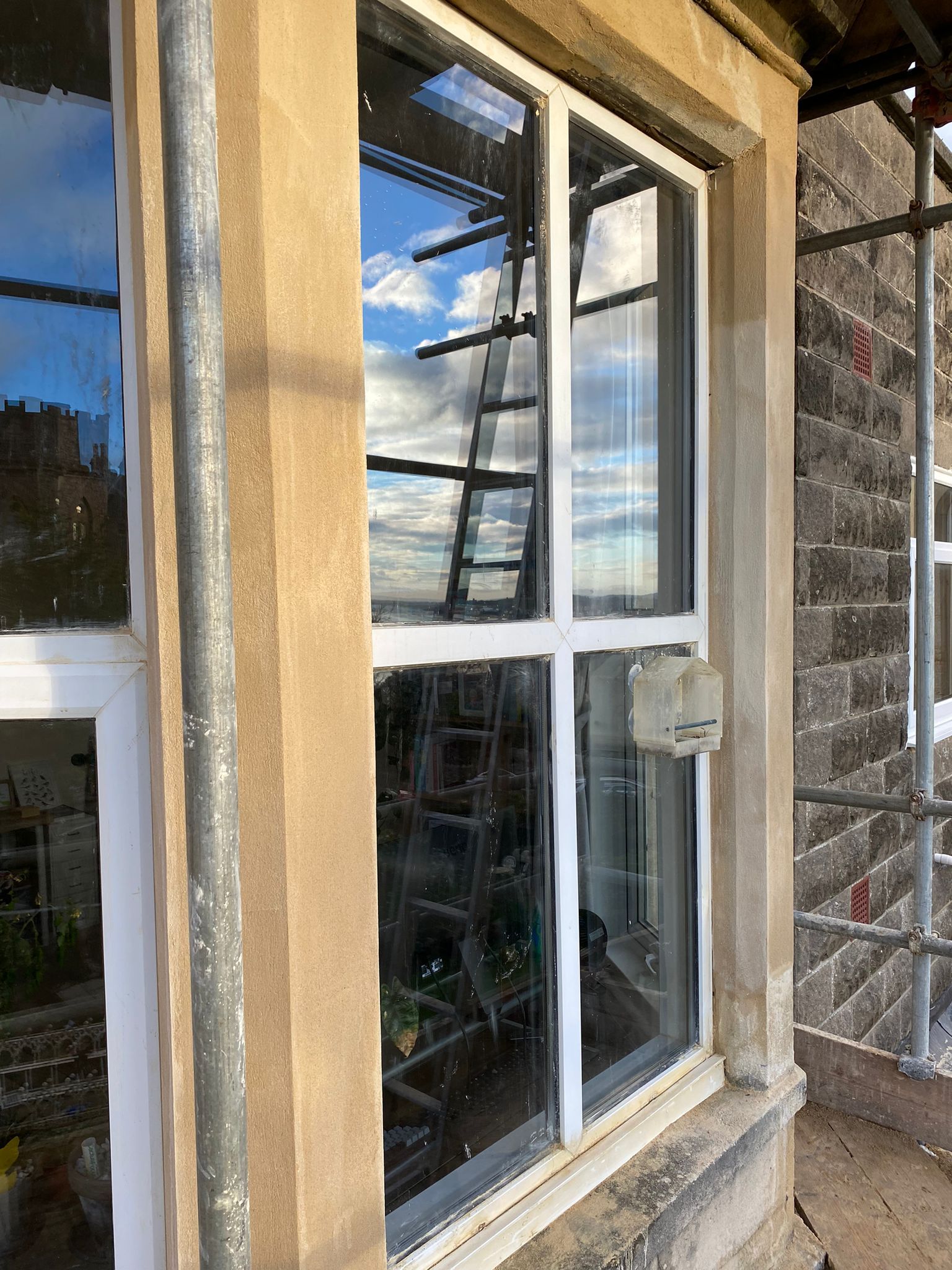 A large window on the side of a building with scaffolding around it.