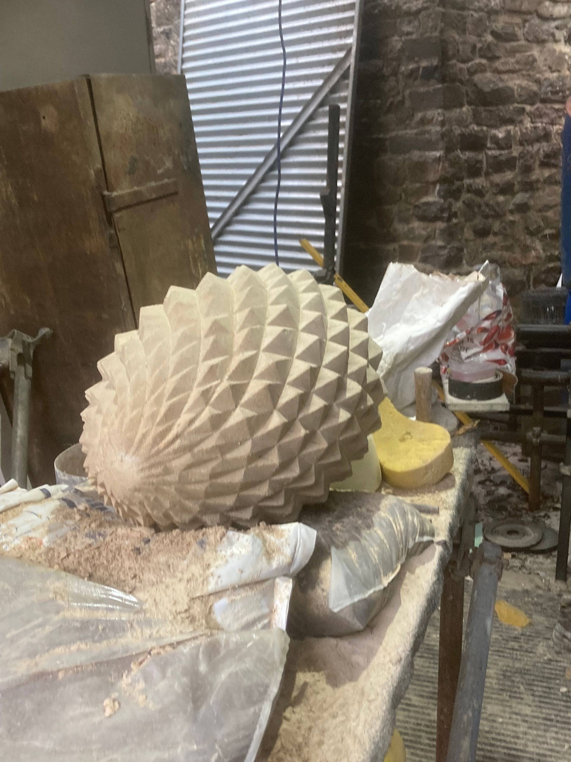 A large pine cone is sitting on top of a wooden table.