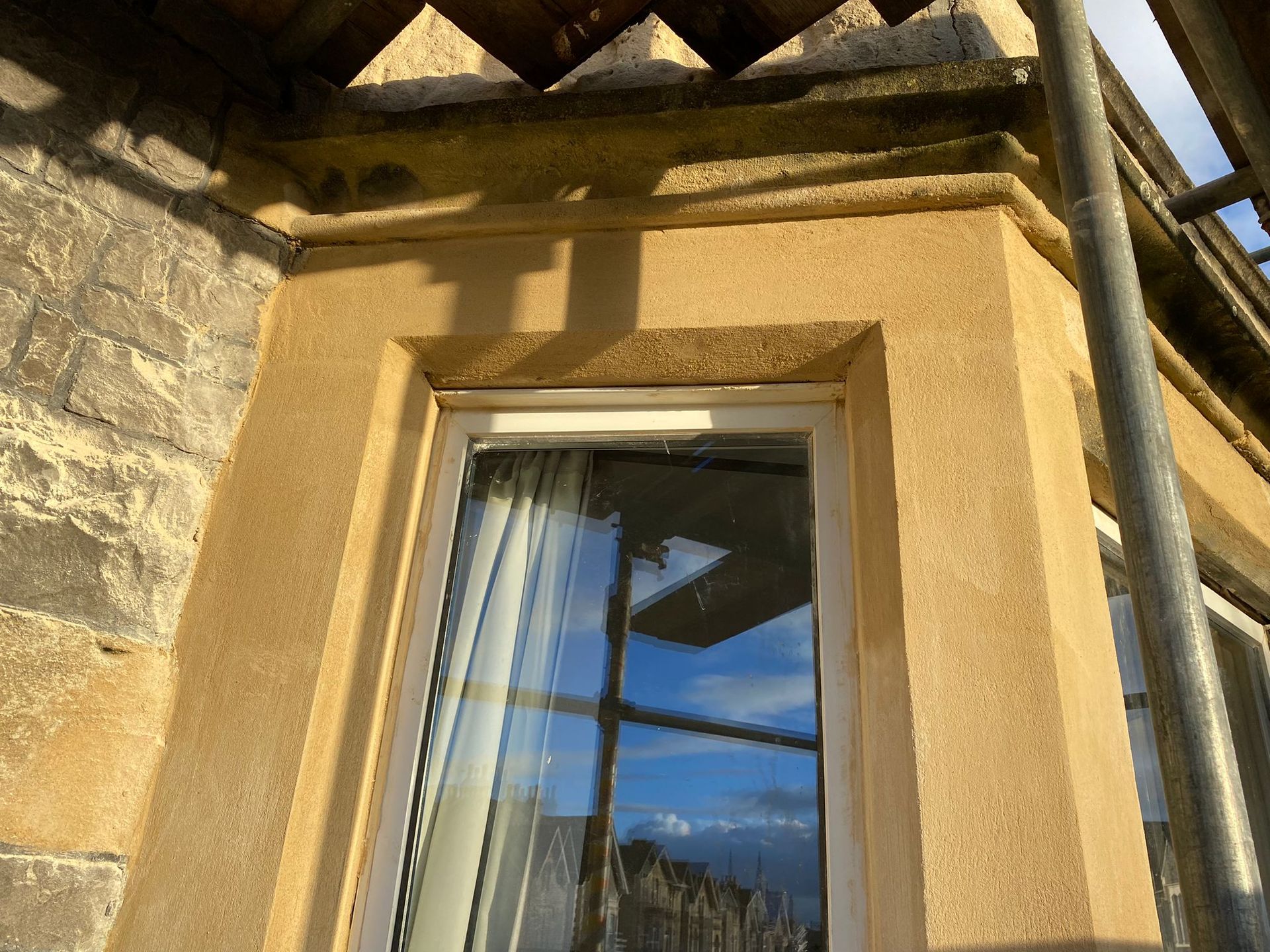 A window on the side of a building with scaffolding around it.