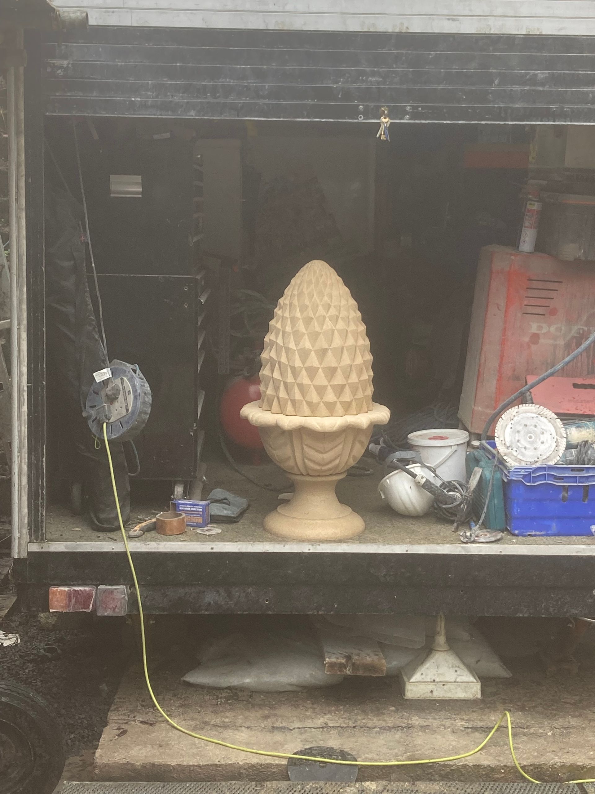 A large pine cone is sitting in the back of a truck.