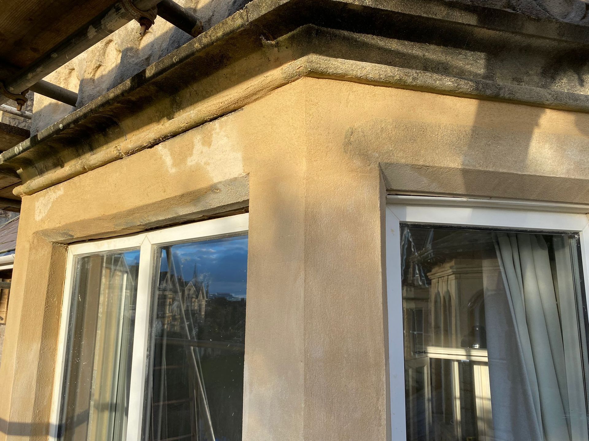 A window on the side of a building with a white frame.