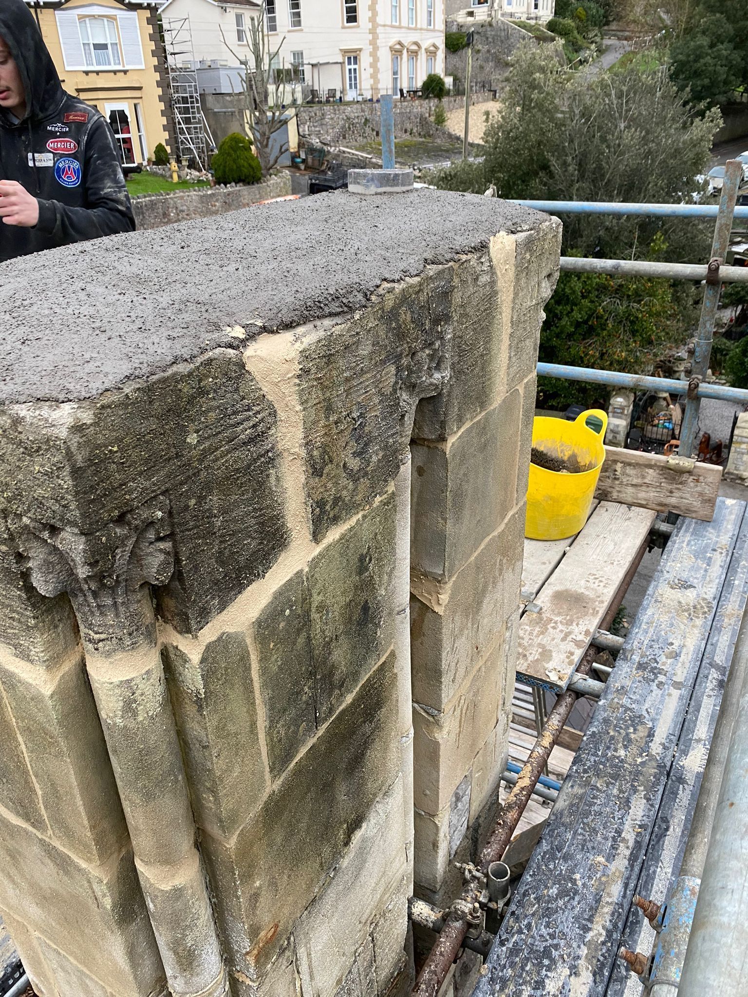 A man is standing on top of a brick wall.