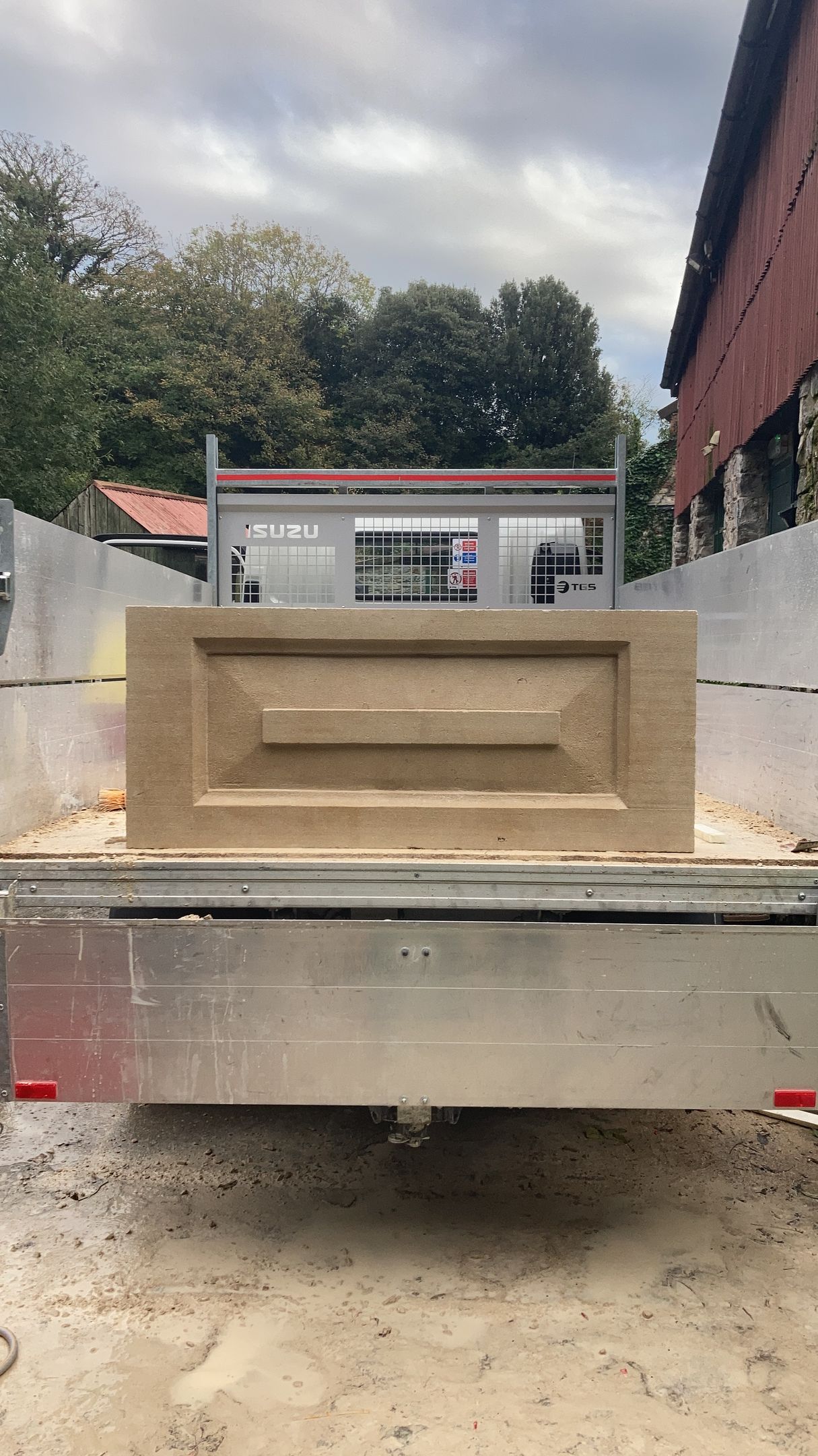 A brick is sitting on the back of a truck.