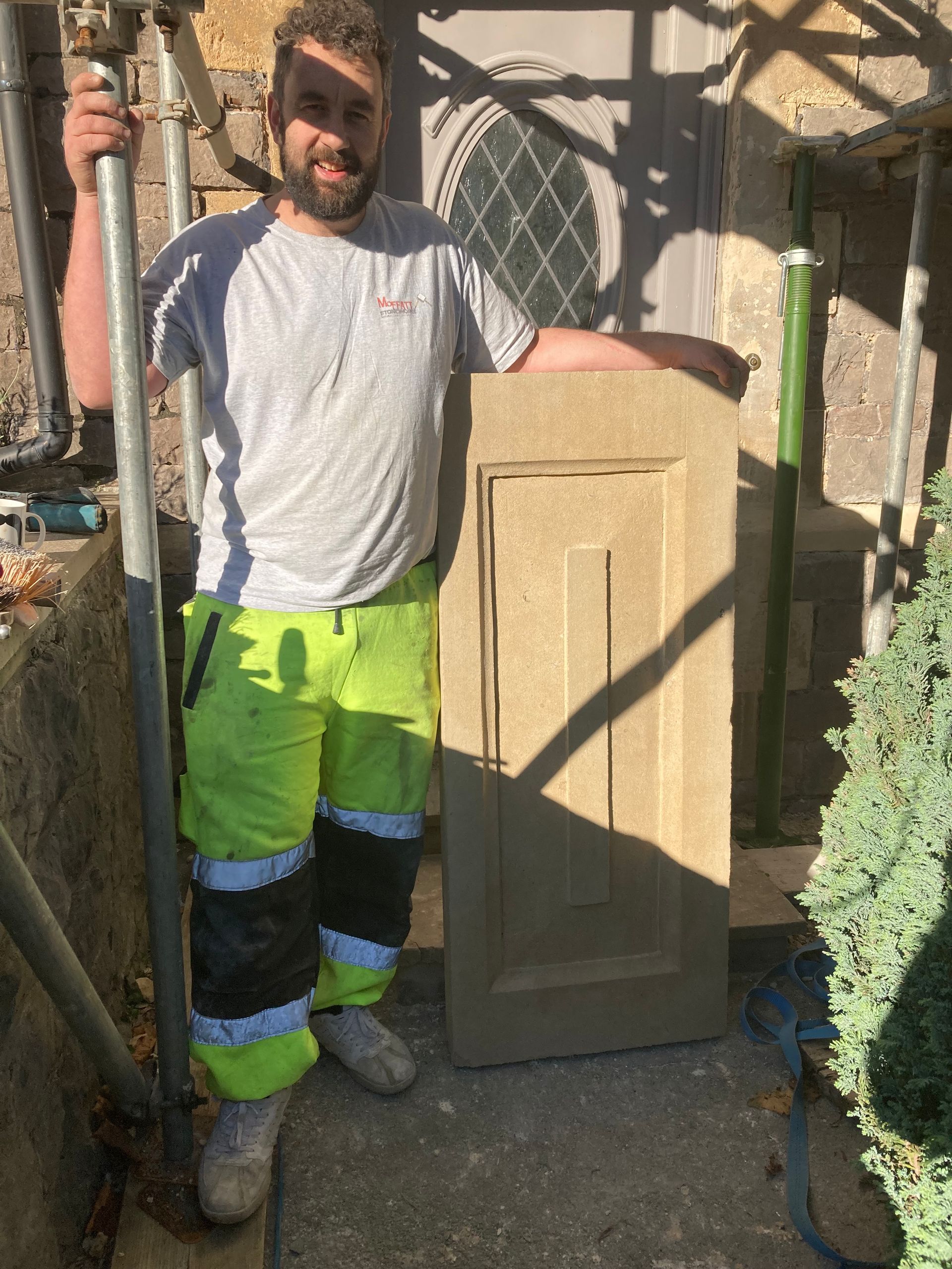 A man in yellow pants is standing next to a door