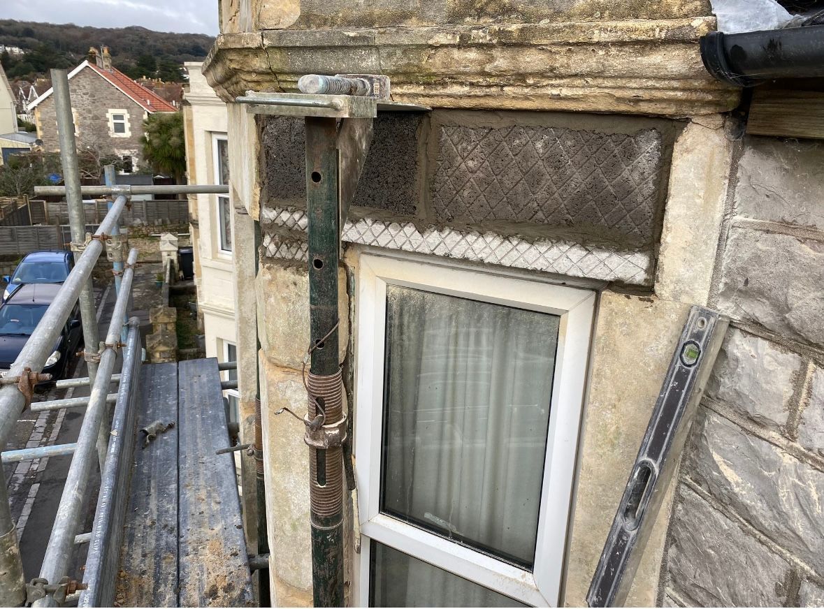 A window on the side of a building with scaffolding around it.