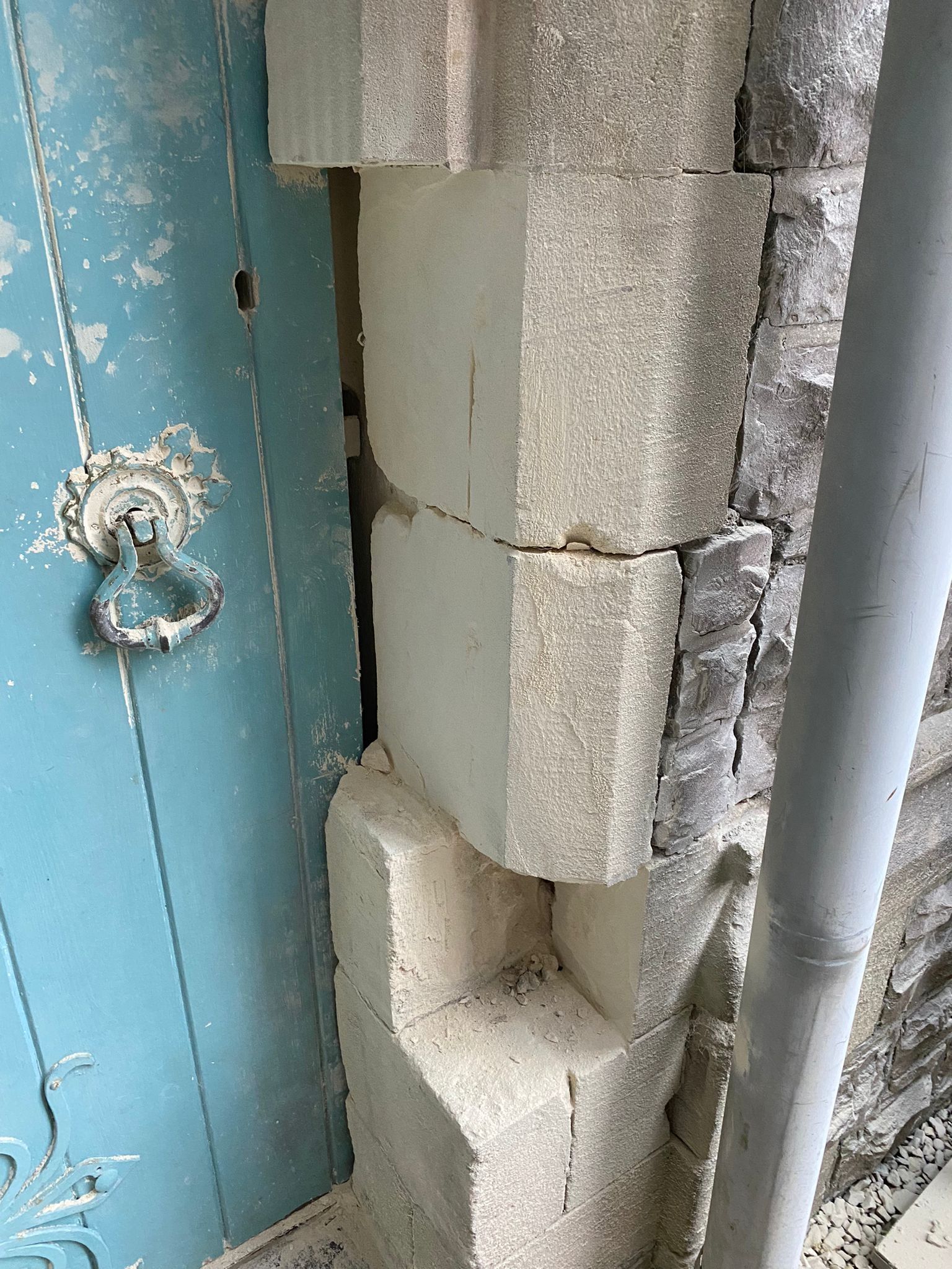 A close up of a brick wall next to a blue door.