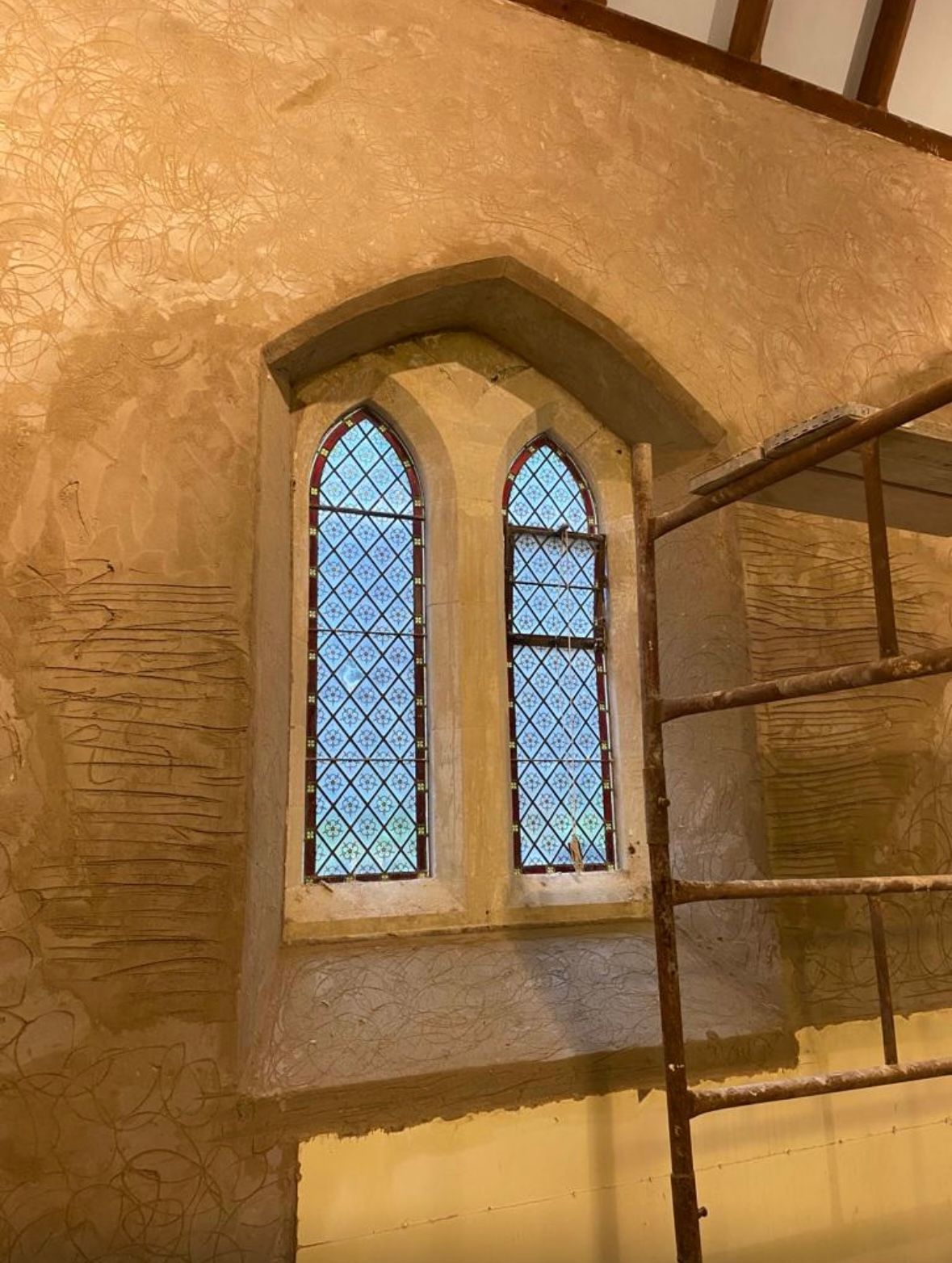 A scaffolding is sitting next to a window in a building.