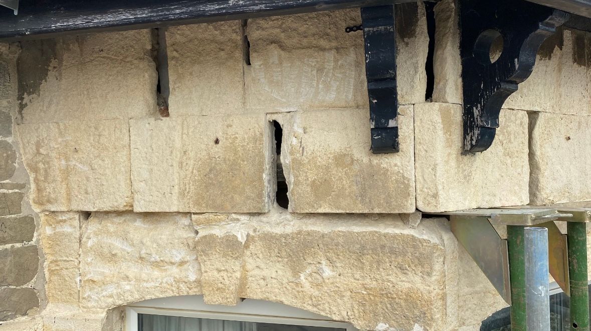 A close up of a stone wall with a window.