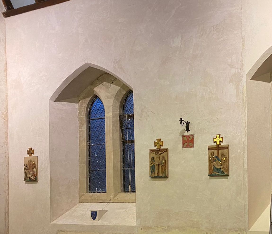 A church with a stained glass window and religious icons on the wall.
