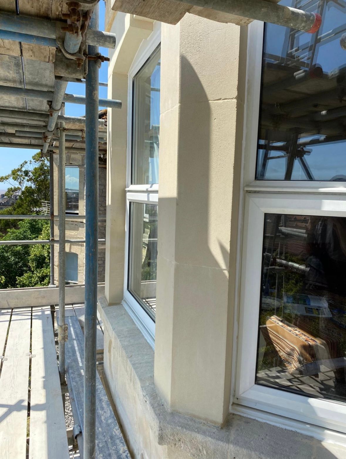 A window on the side of a building with scaffolding around it.