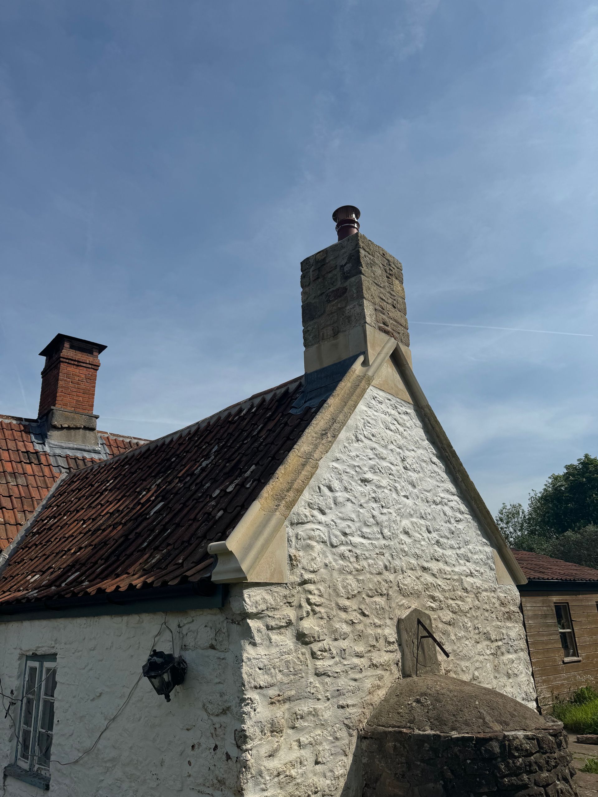 A stone building with a chimney on top of it