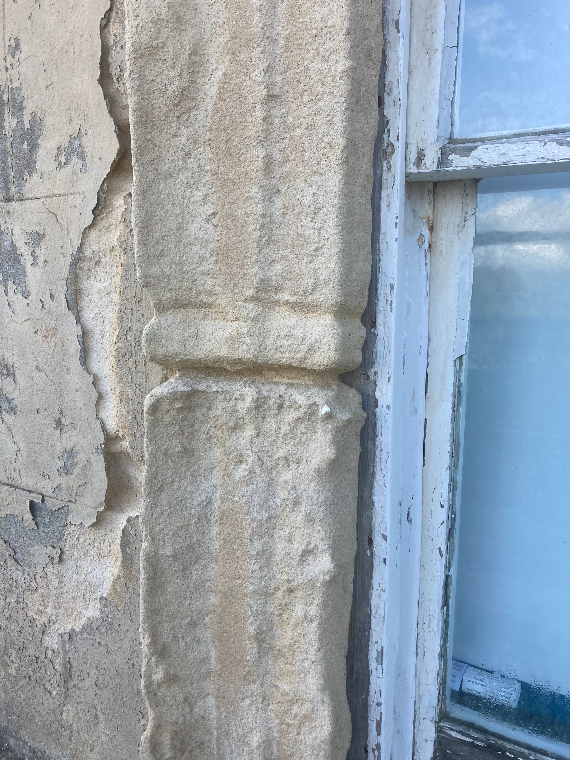 A close up of a stone wall next to a window.