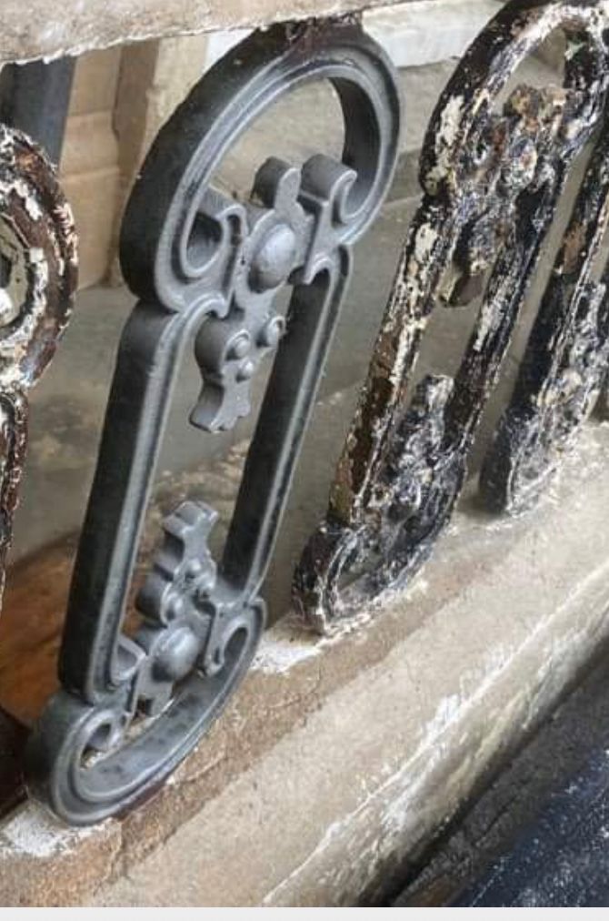 A close up of a metal railing with a letter b on it.