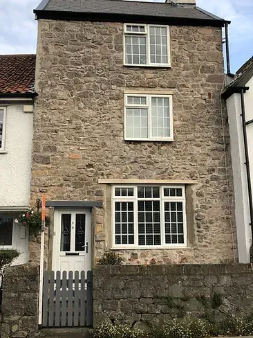 A large stone house with a white door and windows.
