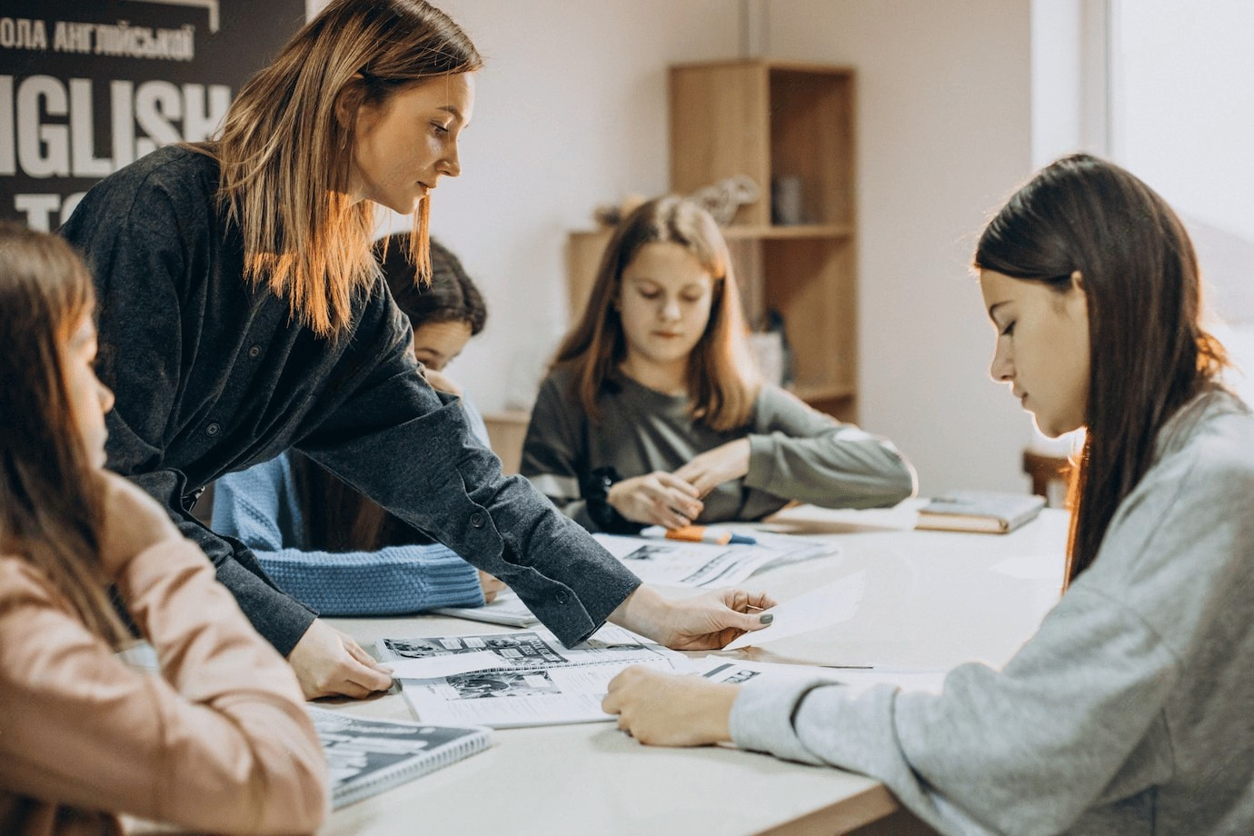 Un profesor está enseñando a un grupo de estudiantes en un salón de clases.