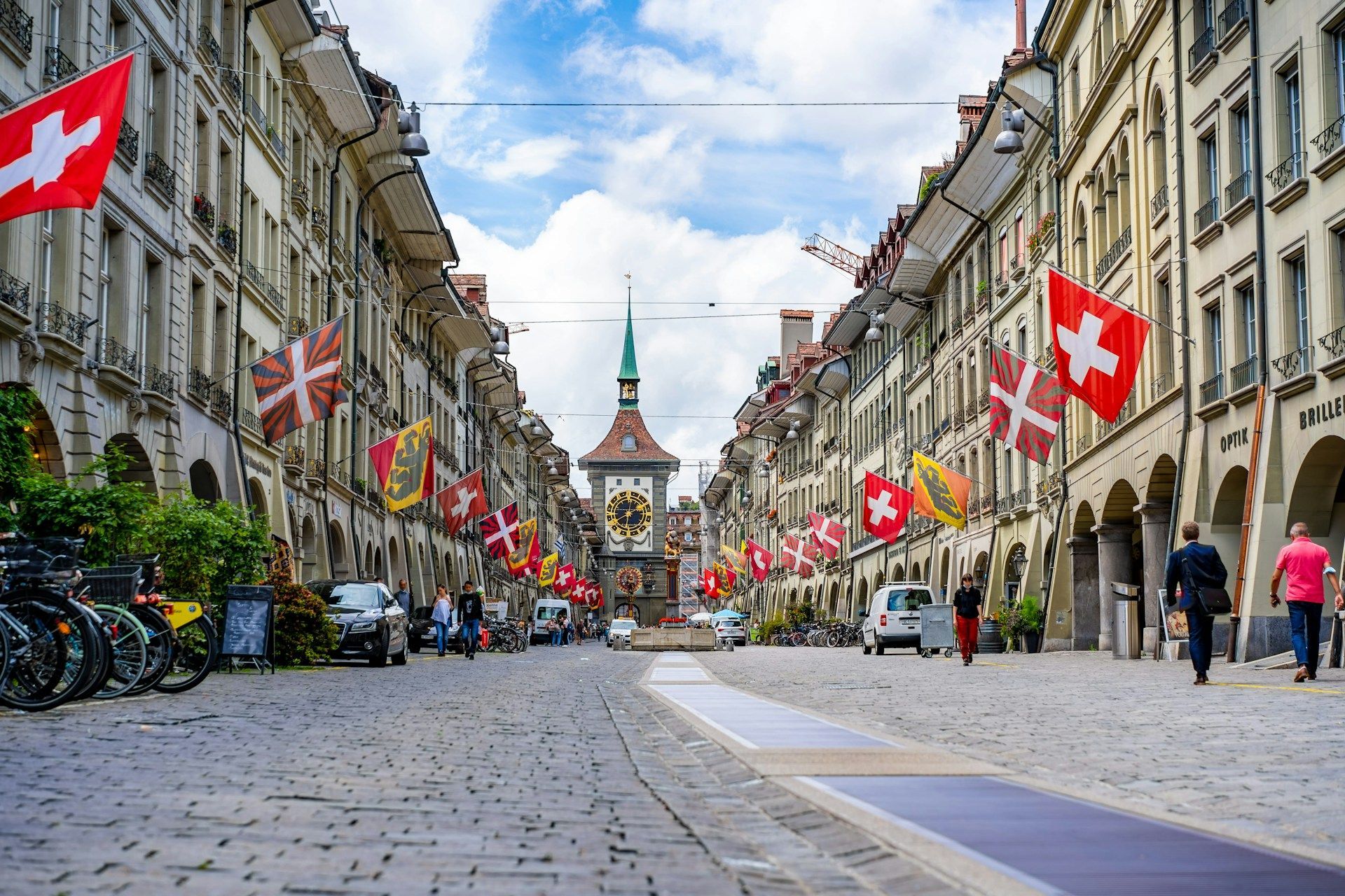 Una calle adoquinada en una ciudad con banderas colgando de los edificios.