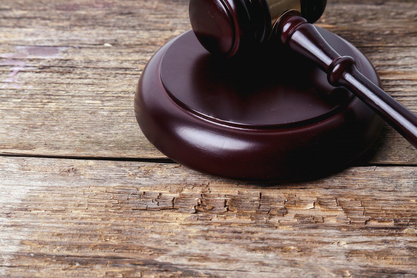 El mazo de un juez de madera está sentado sobre una mesa de madera.