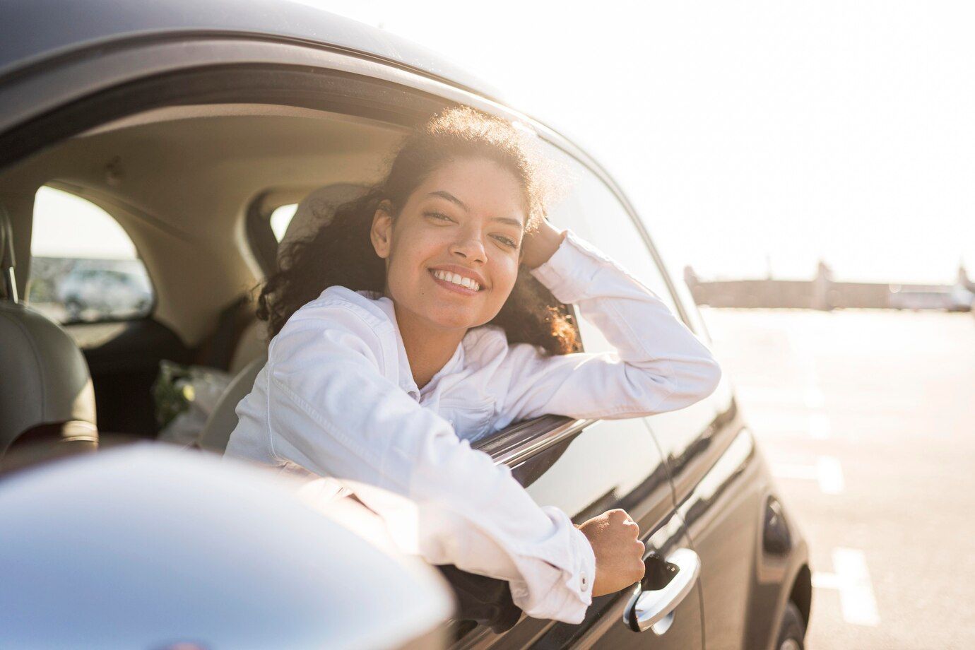Una mujer sonríe mientras está sentada en un coche.