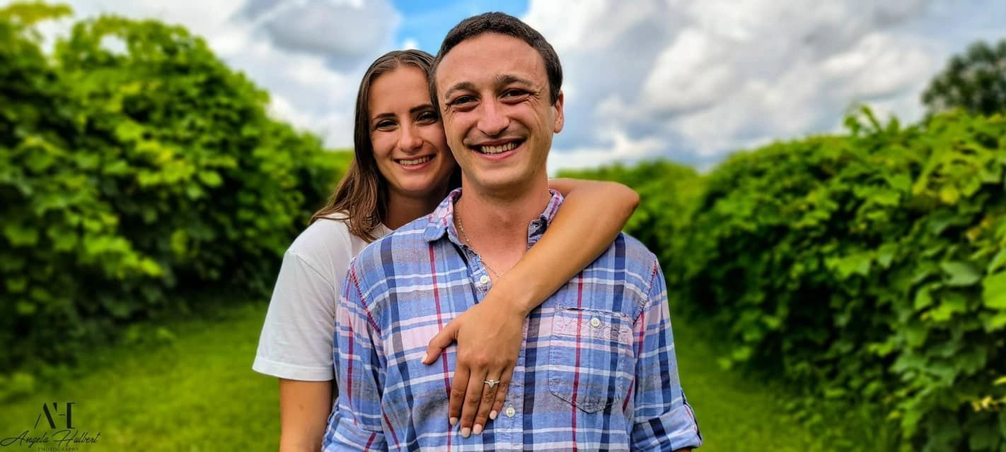 A man and a woman are standing next to each other in a field.