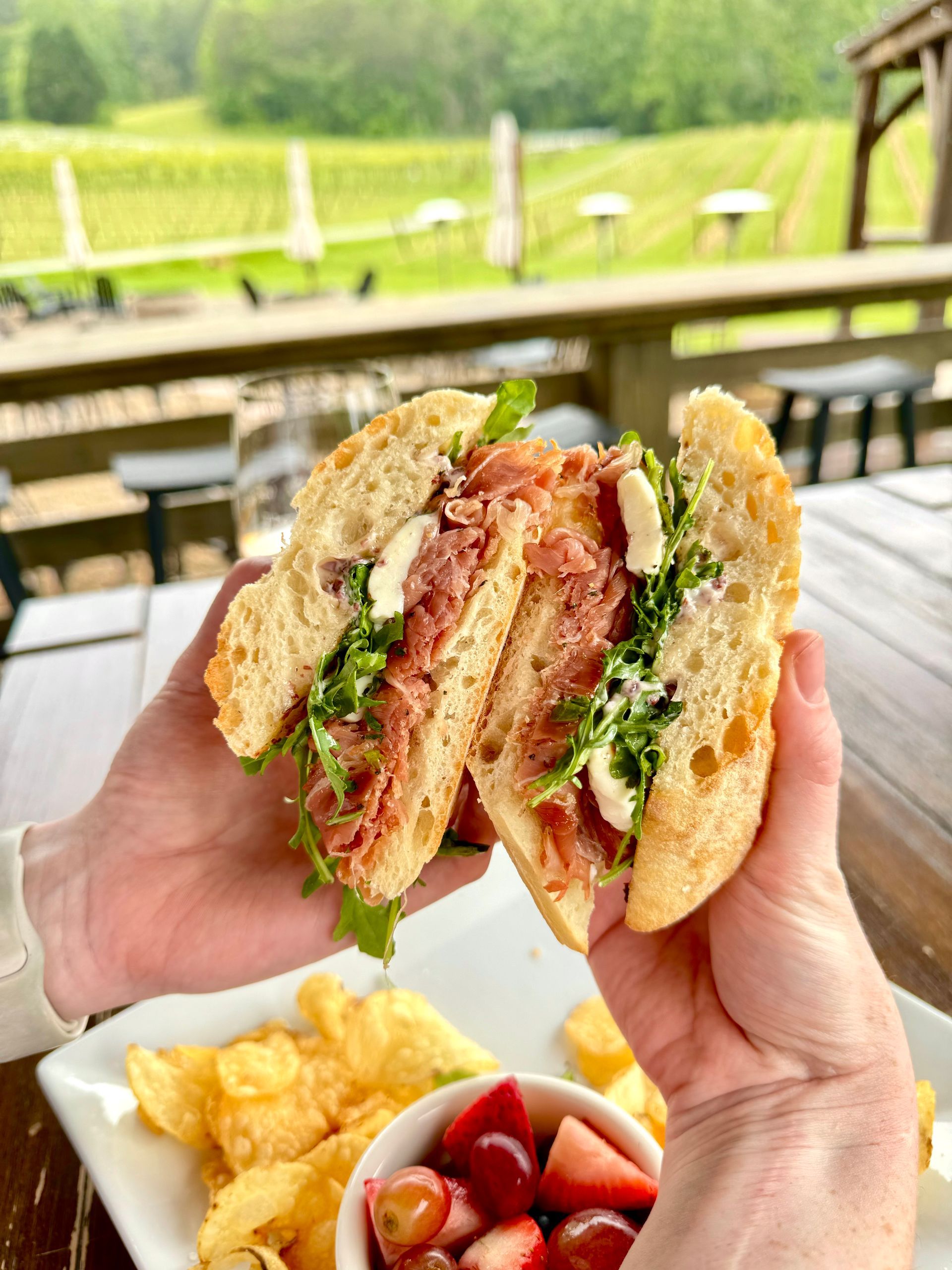 A row of wine bottles are lined up on wooden shelves.