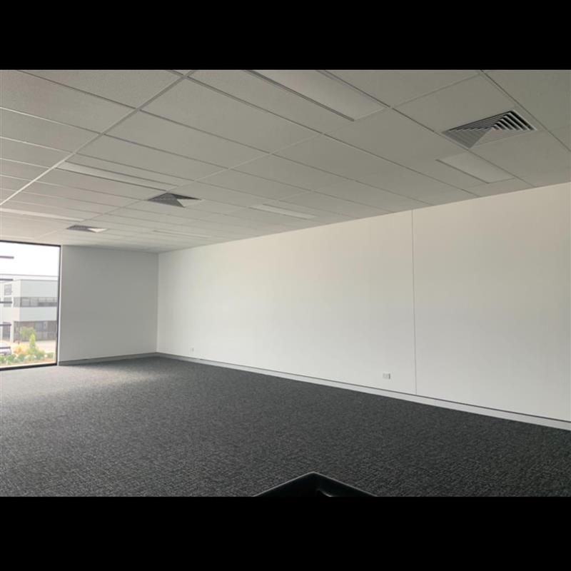 A large empty room with a carpeted floor and white walls.