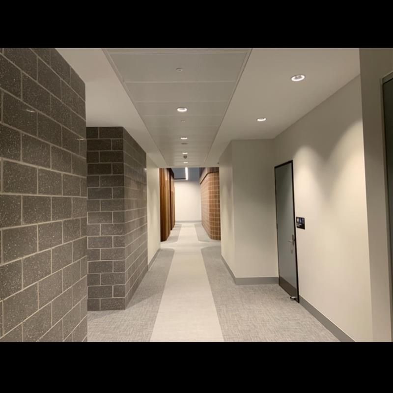 A long hallway with brick walls and a door