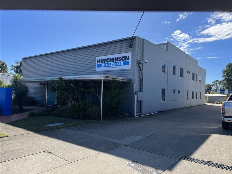 A white truck is parked in front of a building that says hutchinson on it.