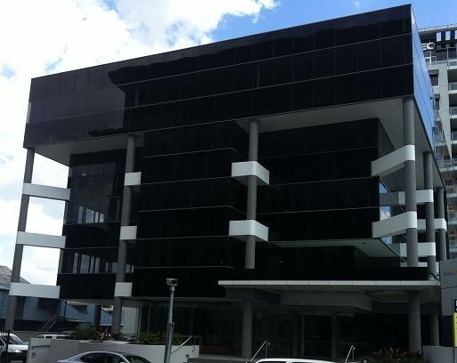 A large black building with a car parked in front of it