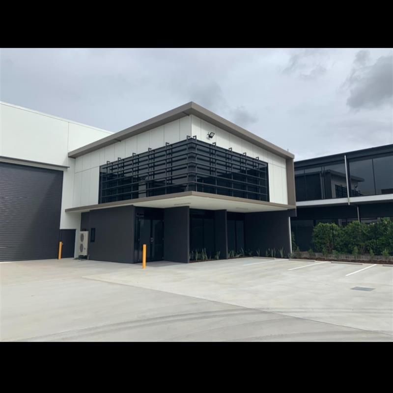 A large building with a lot of windows and a parking lot in front of it.